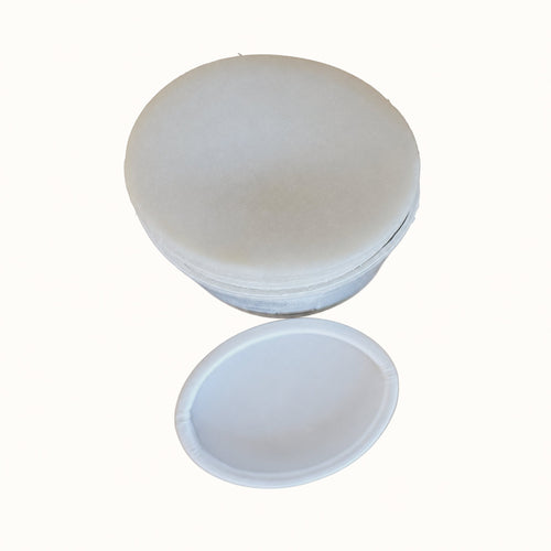 A white circular tube of deodorant with its matching lid resting below it, isolated on a solid white background.